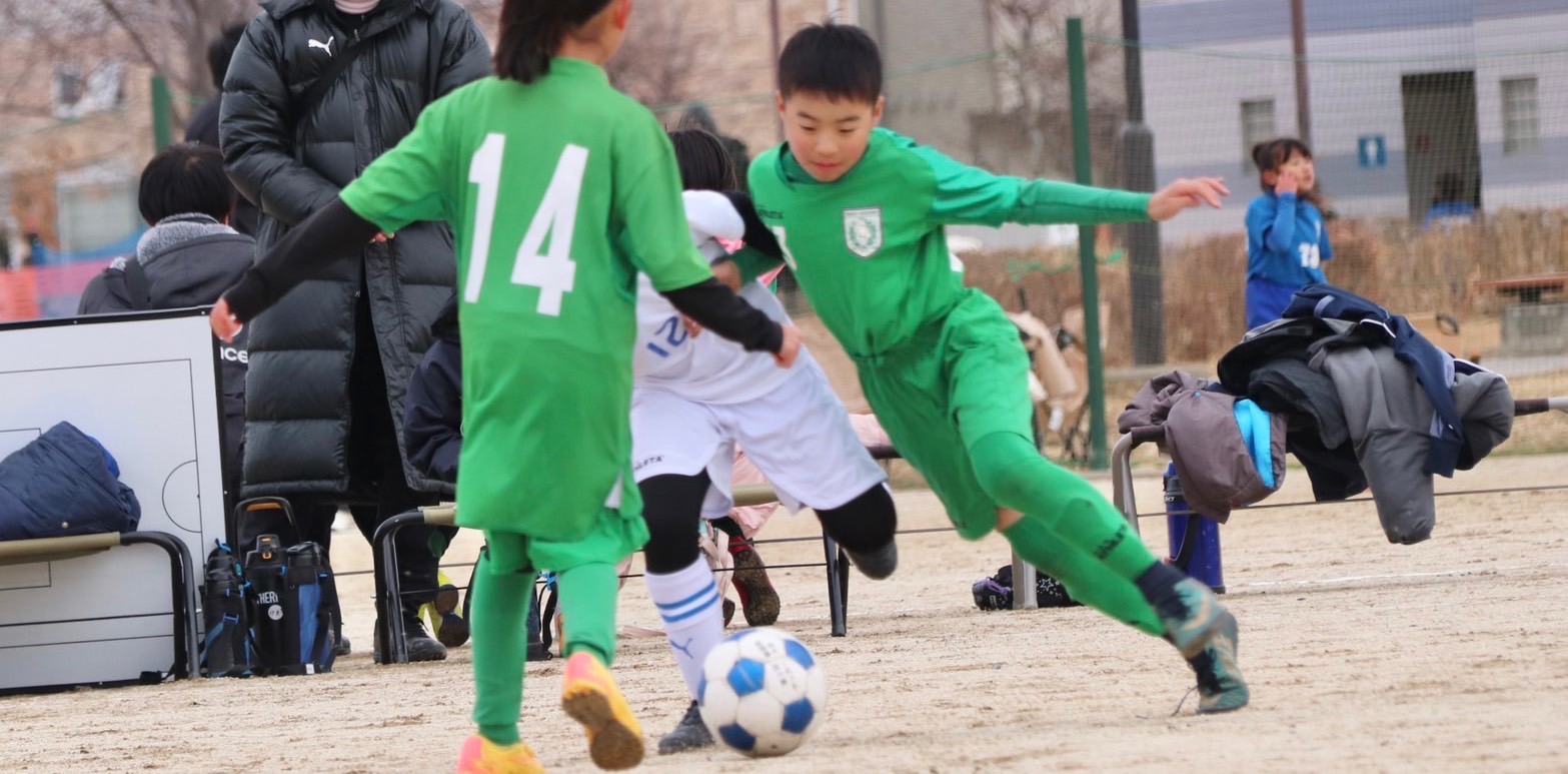 緑のユニフォームでボールを追うロードガーデンFCの選手たち